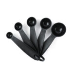 Set of five black measuring spoons with ring holder included in the Le Regalo 33-piece kitchen utensil set.