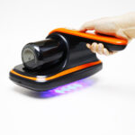 Hand holding American Builder cordless mattress vacuum for upholstery and furniture cleaning