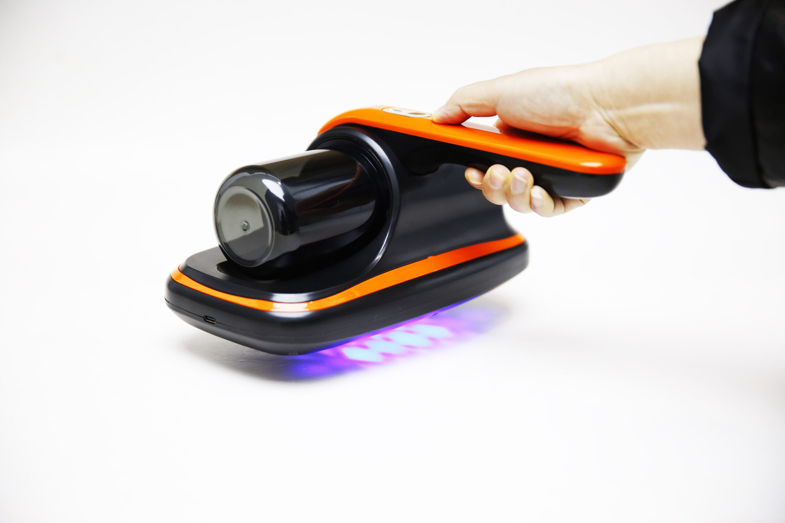 Hand holding American Builder cordless mattress vacuum for upholstery and furniture cleaning